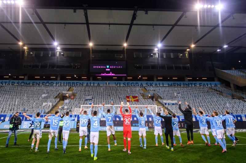 Fotbollslag jublar framför tom läktare under coronapandemin