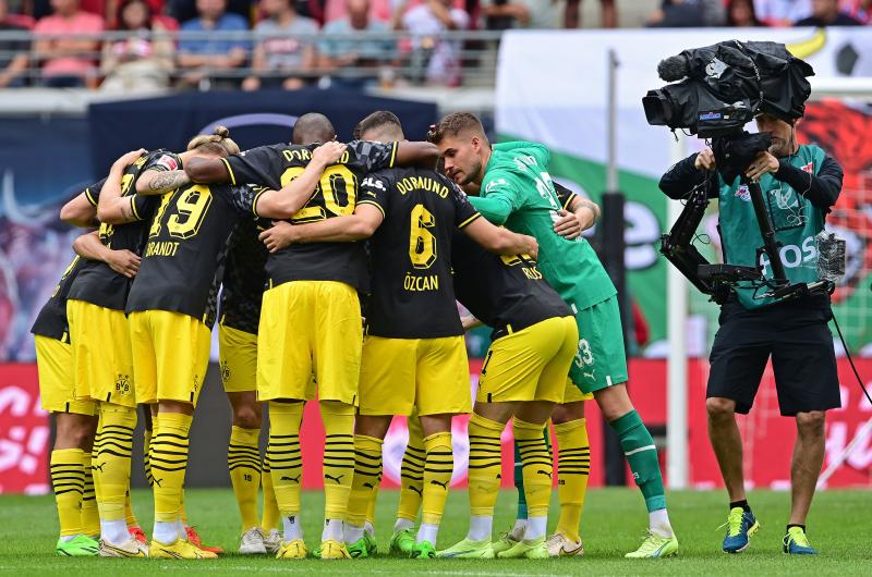 Fotbollsspelare samtalar i grupp. En kamera registrerar.