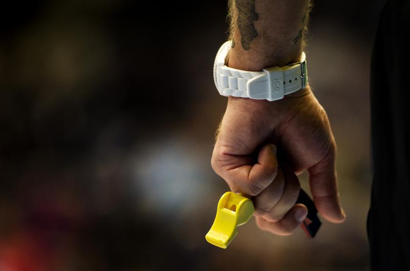 Domare håller visselpipor i handen. 