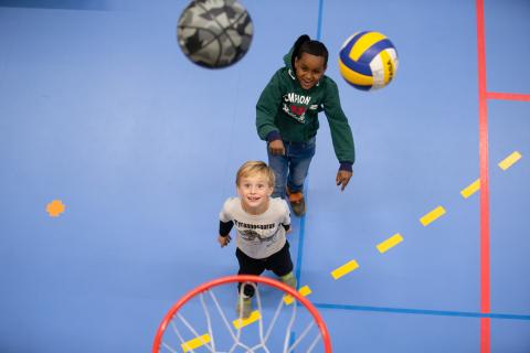 Två barn spelar basket
