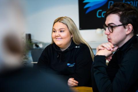 Kvinna sitter vid mötesbord.