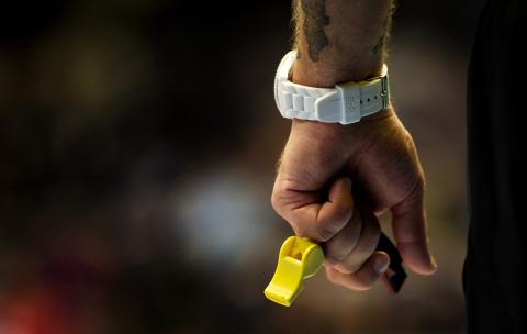 Domare håller visselpipor i handen. 