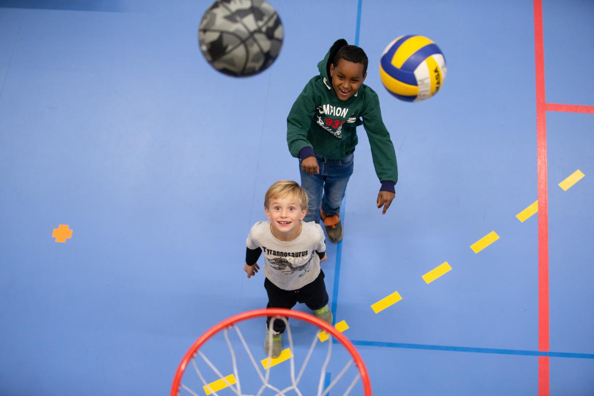 Två barn spelar basket